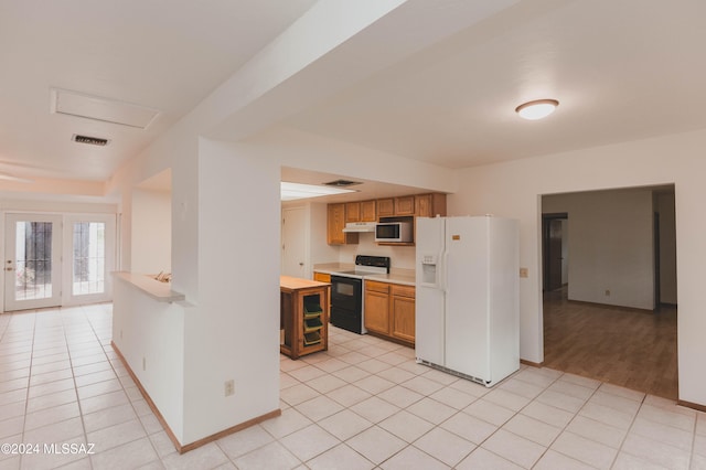 kitchen featuring light tile patterned floors and white appliances