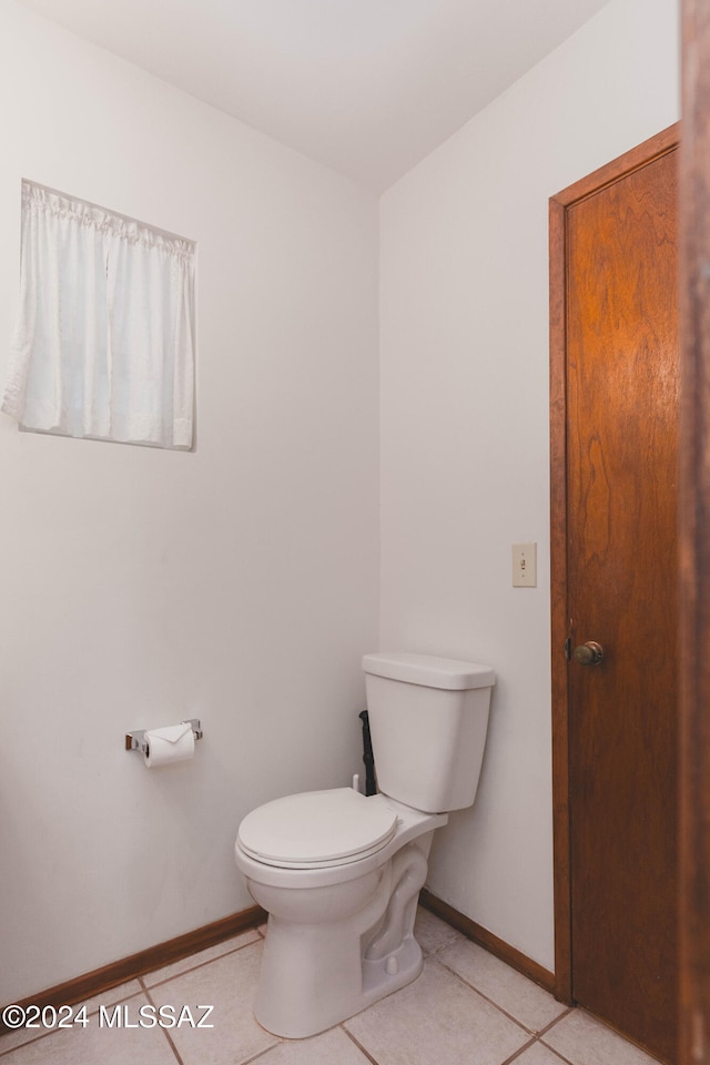 bathroom with tile patterned flooring, vanity, toilet, and walk in shower