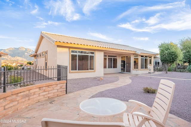 rear view of house with a mountain view and a patio