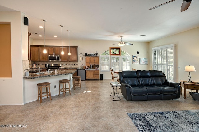 living room featuring ceiling fan and sink