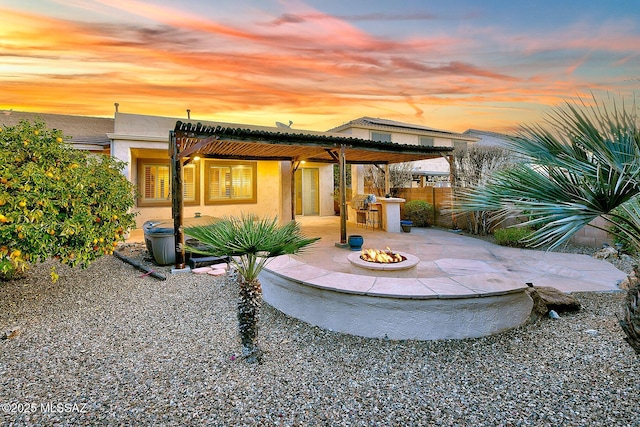 patio terrace at dusk featuring a bar and a fire pit