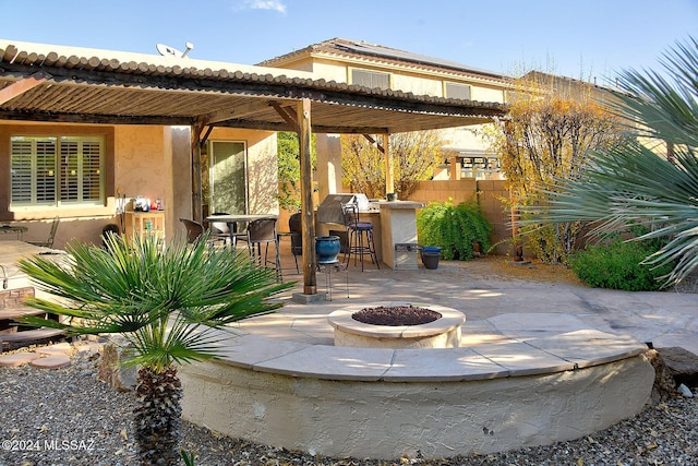 view of patio / terrace featuring an outdoor fire pit and exterior bar