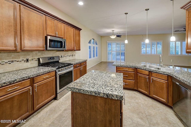 kitchen featuring decorative backsplash, sink, stainless steel appliances, and a kitchen island