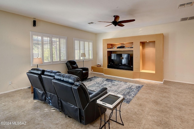 living room featuring ceiling fan and built in shelves