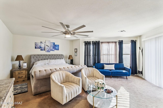 carpeted bedroom with a textured ceiling and ceiling fan