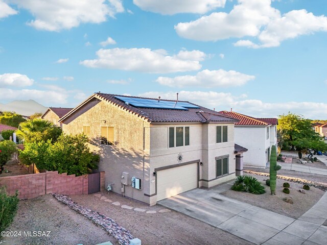 3457 N Crystal Hill Ave, Tucson, AZ 85745 - mediterranean / spanish-style home with an attached garage, a tiled roof, stucco siding, driveway, and solar panels