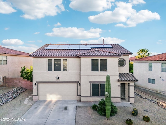 view of front of home featuring solar panels and a garage