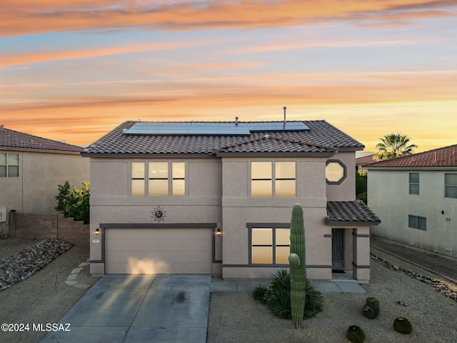 view of front facade featuring solar panels and a garage