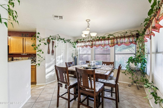 dining room with a wealth of natural light, light tile patterned flooring, and a textured ceiling