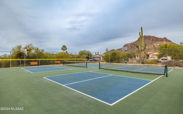 view of sport court with basketball hoop and a mountain view