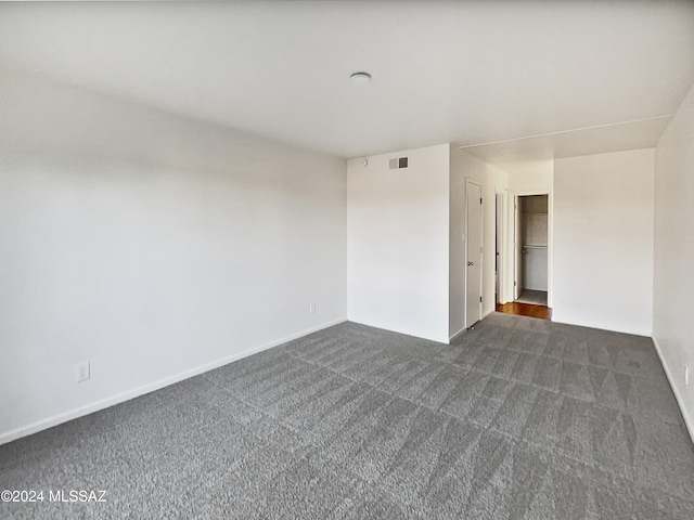 unfurnished room featuring dark carpet