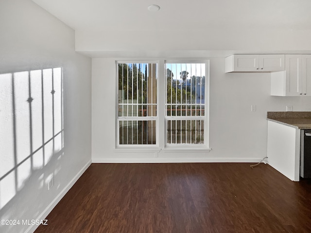 unfurnished dining area featuring dark wood-type flooring