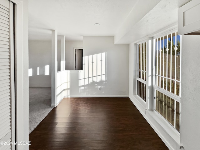 unfurnished room with a textured ceiling and dark wood-type flooring