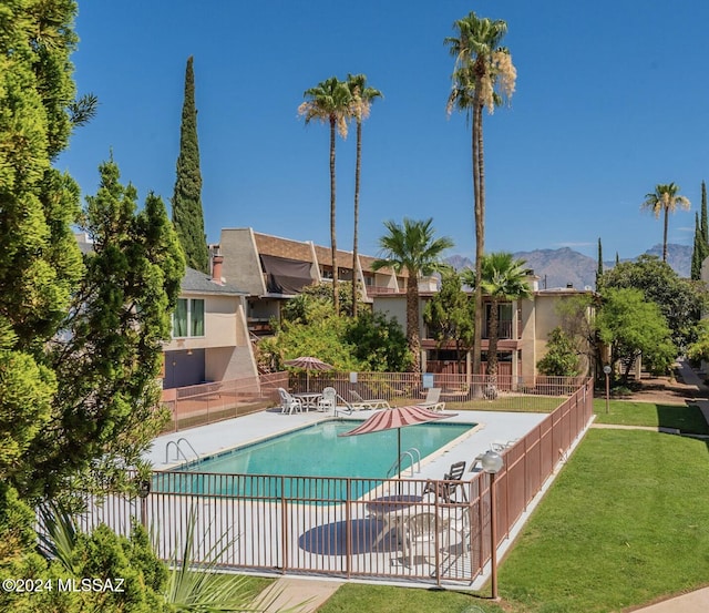 view of pool with a mountain view, a yard, and a patio