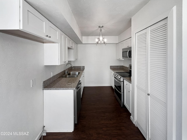 kitchen featuring white cabinetry, sink, dark wood-type flooring, pendant lighting, and appliances with stainless steel finishes