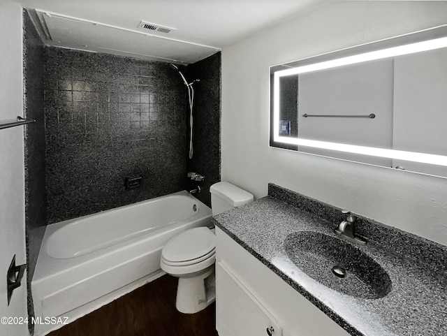 full bathroom featuring tiled shower / bath combo, toilet, wood-type flooring, and vanity