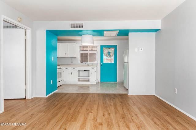 unfurnished living room with sink and light hardwood / wood-style floors