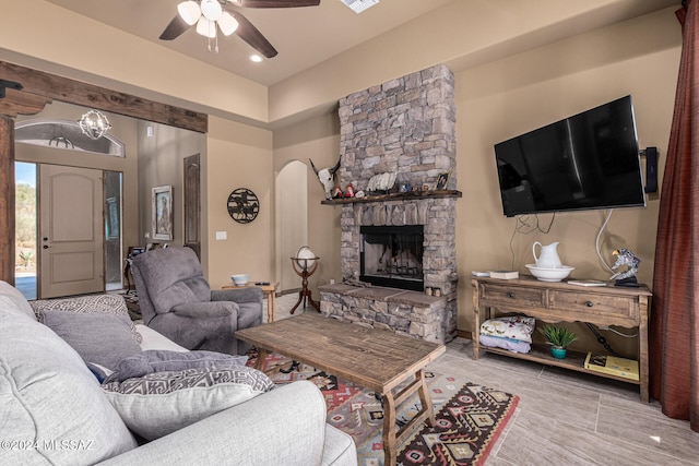 living room with ceiling fan and a fireplace