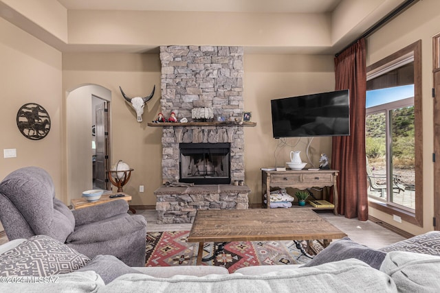 living room featuring a stone fireplace