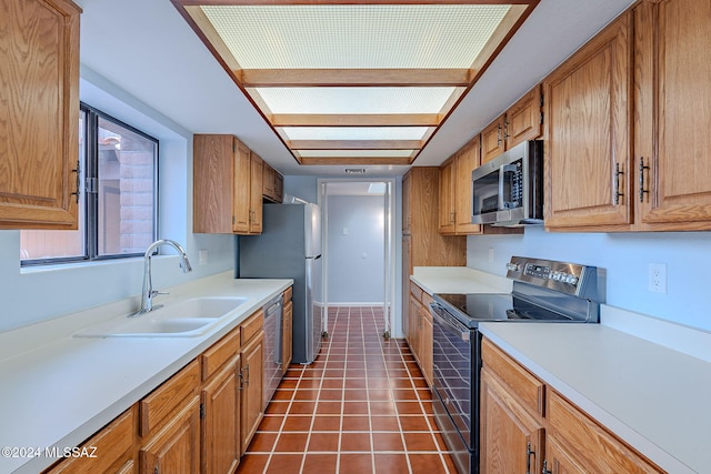 kitchen featuring sink, dark tile patterned floors, and appliances with stainless steel finishes