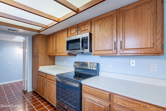 kitchen featuring dark tile patterned floors and stainless steel appliances