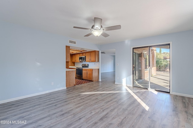 unfurnished living room featuring ceiling fan and light wood-type flooring