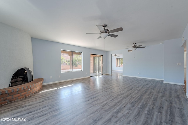 unfurnished living room featuring a fireplace, ceiling fan, and light hardwood / wood-style flooring