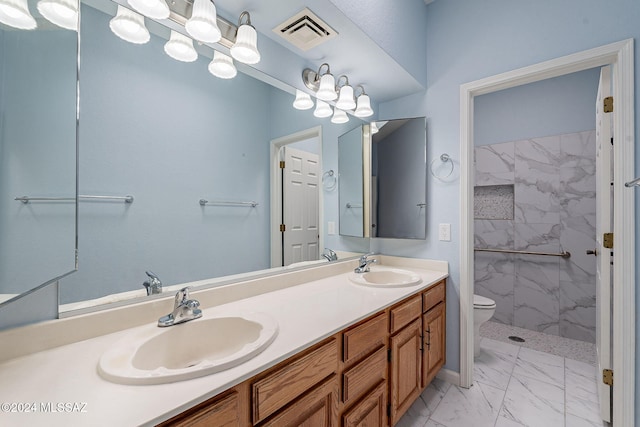 bathroom with a tile shower, vanity, and toilet