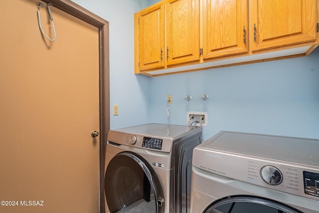 laundry room with cabinets and washer and clothes dryer