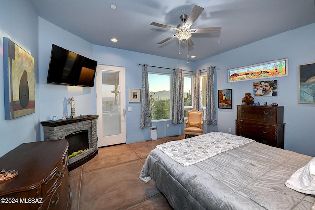 bedroom with ceiling fan and a fireplace