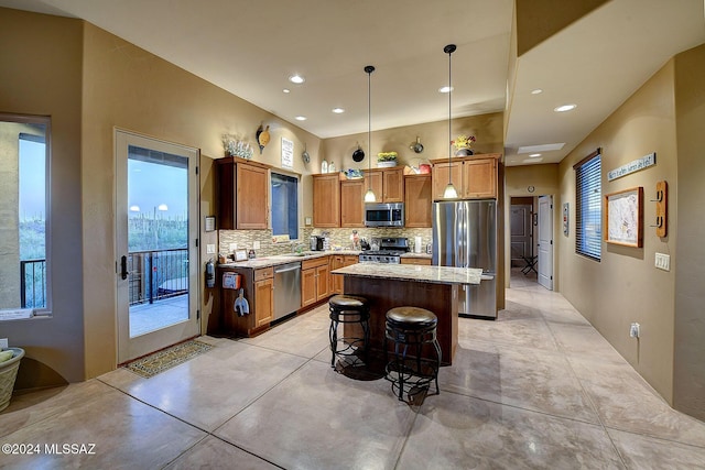 kitchen featuring a wealth of natural light, a kitchen island, hanging light fixtures, and appliances with stainless steel finishes