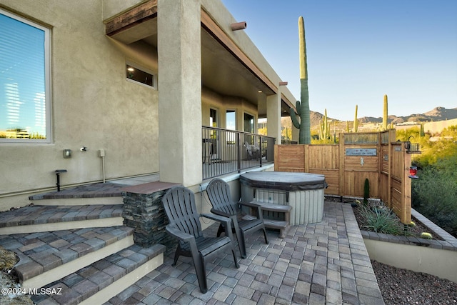 view of patio featuring a mountain view and a hot tub