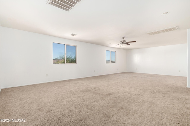 carpeted empty room featuring ceiling fan and a wealth of natural light