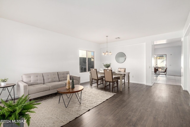 living room featuring dark wood-type flooring and a notable chandelier