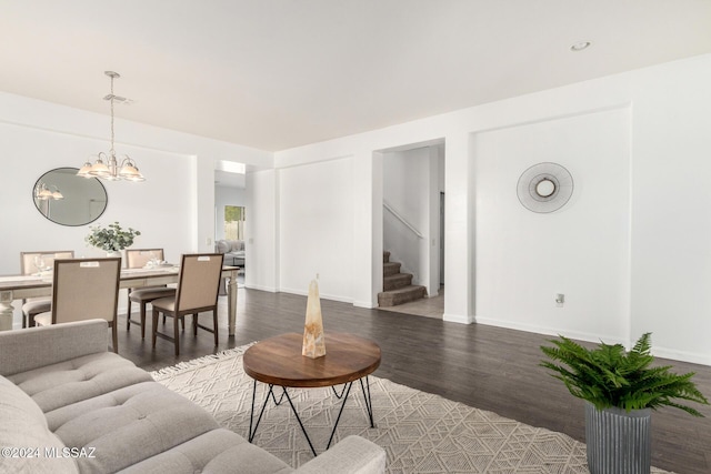 living room with dark wood-type flooring and an inviting chandelier