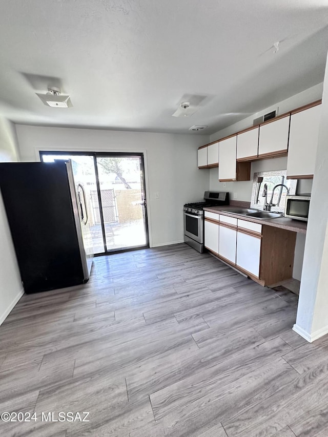 350 N Silverbell Rd Unit 96, Tucson, AZ 85745 - kitchen featuring appliances with stainless steel finishes, white cabinets, a sink, and baseboards