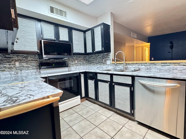 kitchen featuring light tile patterned flooring, appliances with stainless steel finishes, tasteful backsplash, and sink