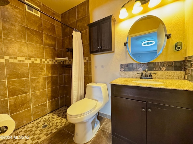 bathroom with a shower with curtain, vanity, toilet, and tile patterned floors