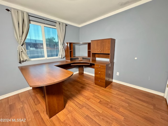 unfurnished office featuring light wood-type flooring and crown molding