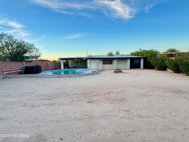 exterior space with a fenced in pool and a fire pit