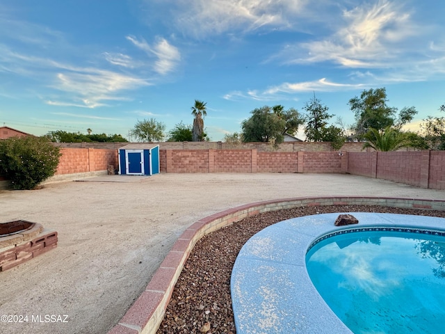 view of swimming pool featuring a storage unit and a patio area