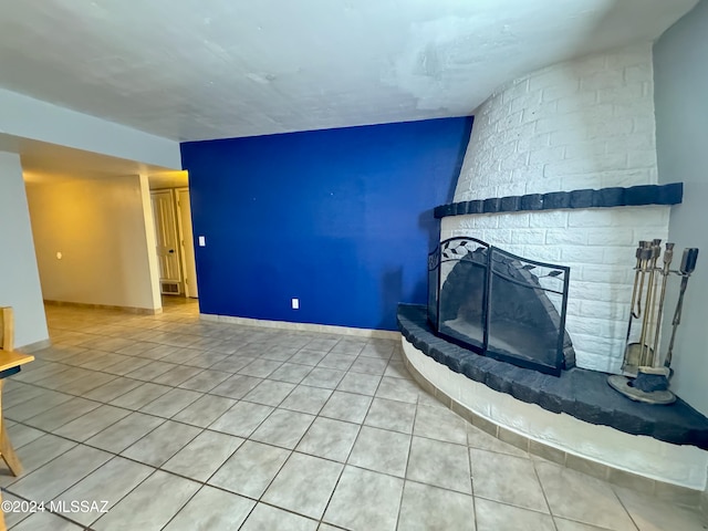 unfurnished living room featuring tile patterned floors and a stone fireplace