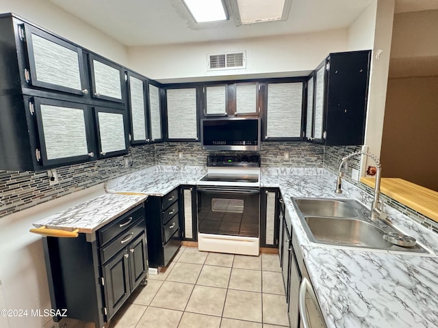 kitchen featuring decorative backsplash, light tile patterned flooring, electric stove, and sink