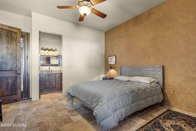 bedroom with ceiling fan, sink, and connected bathroom