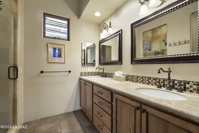 bathroom featuring tile patterned flooring, vanity, tasteful backsplash, and a shower with door