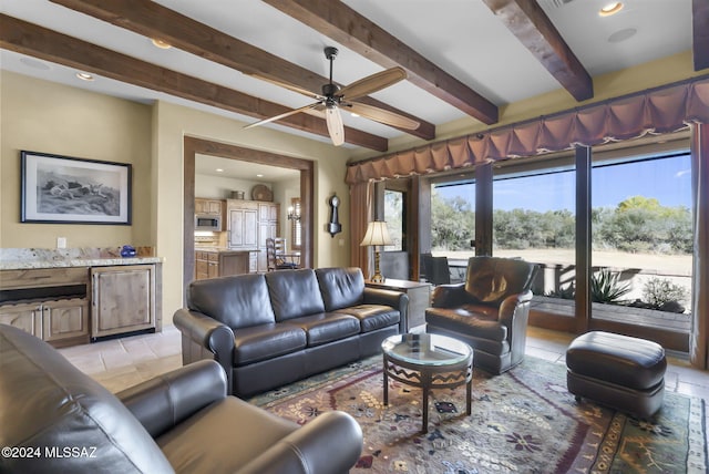 tiled living room with ceiling fan and beamed ceiling