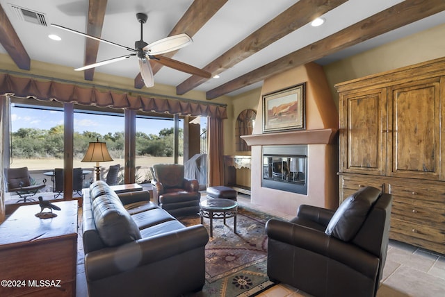 living room with beam ceiling, ceiling fan, and a healthy amount of sunlight