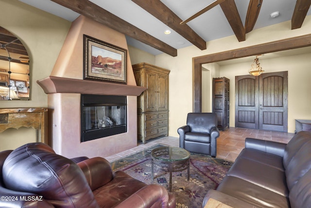 living room with beam ceiling and a large fireplace