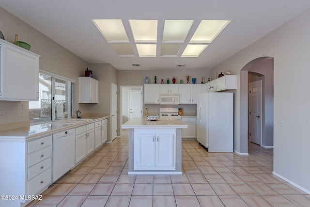 kitchen with a center island, white appliances, sink, and white cabinetry