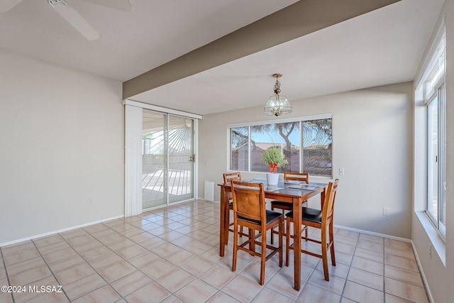 tiled dining room with ceiling fan with notable chandelier